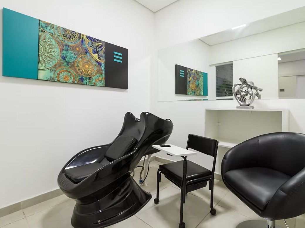 Salão de beleza do Residencial Espaço Saúde com lavatório de cabelo, cadeira, poltrona e bancada com espelho